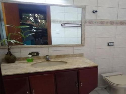 uma casa de banho com um lavatório, um espelho e um WC. em Casa romântica Internet 500Mb em São Paulo