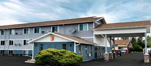 a inn with a blue building with a parking lot at Super 8 by Wyndham Missoula/Brooks Street in Missoula