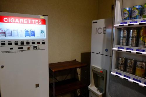 a refrigerator and a soda machine in a room at West Inn Fuji-Yoshida in Fujiyoshida