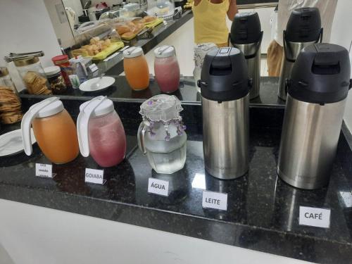 a kitchen counter with a bunch of different types of juice at Pousada Avenida in Teixeira de Freitas