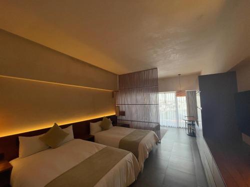 a hotel room with two beds and a window at Hive Cancun by G Hotels in Cancún