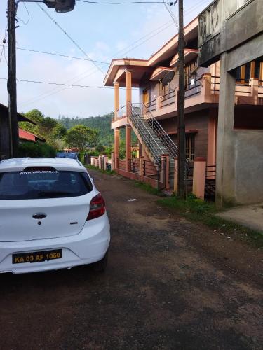 a white car parked in front of a house at Hidden gem home stay in Madikeri