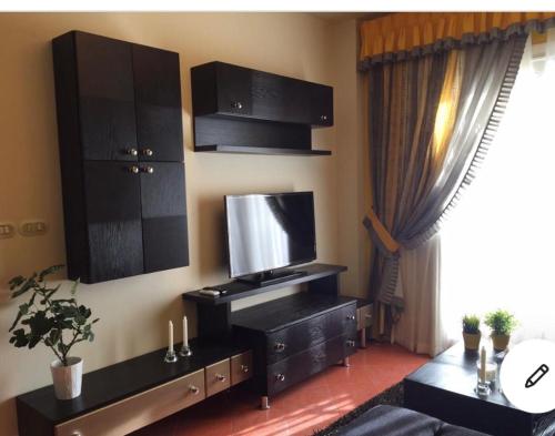a living room with black furniture and a large window at Golf Porto marina in El Alamein