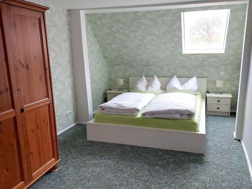 GladauAttic Holiday Home with Garden and Grill的卧室里有一张床，床单和枕头都是白色的