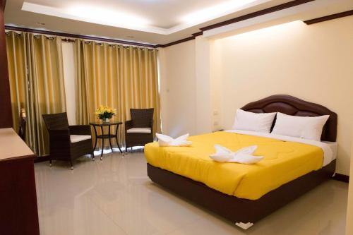 Un dormitorio con una gran cama amarilla con flores. en Honey House 3, en Jomtien Beach