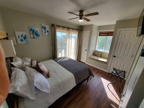 Schlafzimmer mit einem Bett und einem Deckenventilator in der Unterkunft Bear Lake Emerald Retreat with lake view. in Garden City