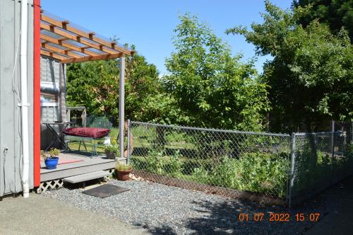 a fence with a bench next to a gate at Estuary House Reflexology B&B in Courtenay