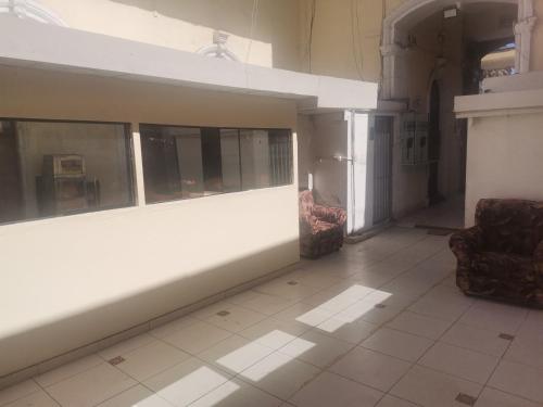 an empty room with two chairs and a wall at Hostal Carmen in Arequipa