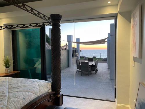 a bedroom with a bed and a view of the ocean at Triton's Playhouse Beachfront in Primo Tapia