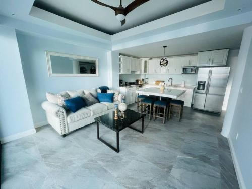 a living room with a couch and a table and a kitchen at Triton's Playhouse Beachfront in Primo Tapia