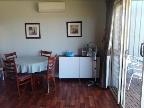 a dining room with a table and chairs and a table at Cabarita Lodge in Mildura