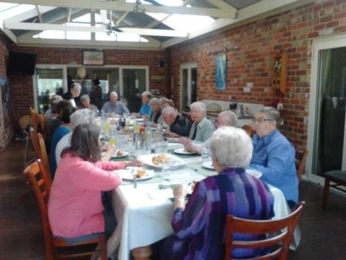 a group of people sitting at a table eating food at Cabarita Lodge in Mildura