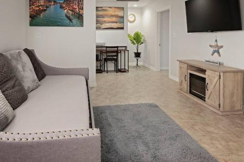 a living room with a couch and a tv at 8 Mins to SPI Beach Spacious 3BR with Backyard in Port Isabel