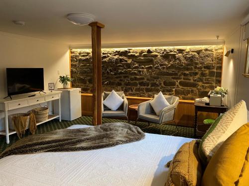 a bedroom with a bed and a stone wall at Hanlon Guest House in Stanley