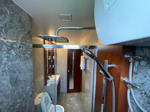a bathroom with a shower with a toilet and a sink at Luxury 3 Room Apartment by Oboe in Male City