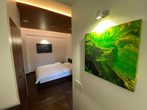 een kamer met een bed en een schilderij aan de muur bij Luxury 3 Room Apartment by Oboe in Male City
