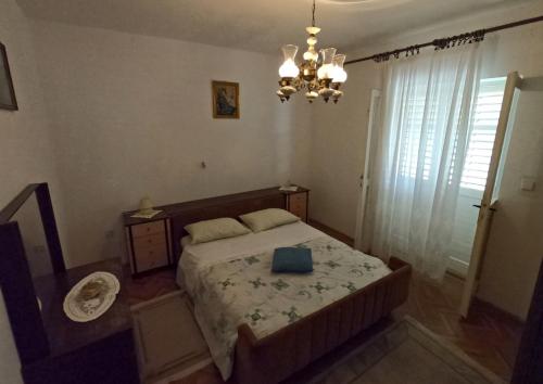 a bedroom with a bed and a chandelier at Apartment Mili - 50m from beach in Sutomišćica