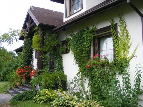 Biały dom z roślinami na boku w obiekcie Dworek Lachowicze w mieście Grzegorzewice