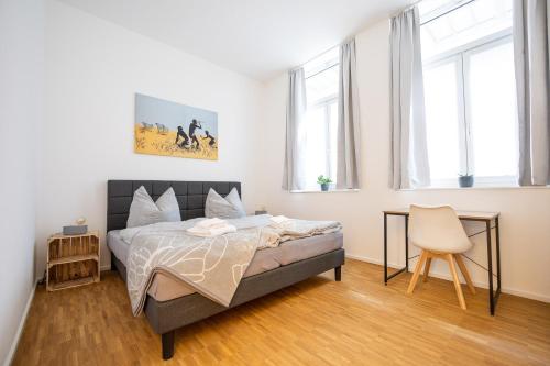 a bedroom with a bed and a chair and windows at Apartments am Eselsbrunnen - Altstadt - Zentral - Küche - Wifi - Powered by Ko-Living in Halle an der Saale