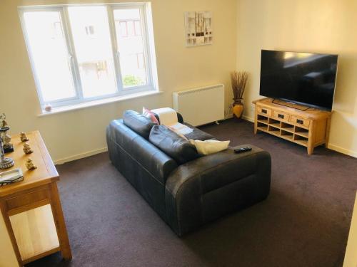 een woonkamer met een bank en een flatscreen-tv bij 2 Bedroom, Near Station, Fast WI-FI, Free Parking! in Londen