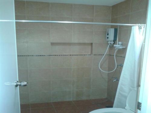 a bathroom with a shower with a toilet at 11th Street Bed and Breakfast in Bacolod