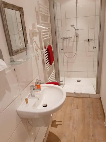 a white bathroom with a sink and a shower at Hotel Columbus und Glamping in Bremerhaven