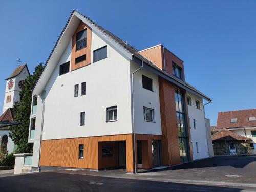 un edificio blanco con techo de gambrel en hb-Gästehaus 