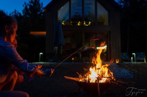 a man is cooking food over a fire at Dziupla House in Czarna