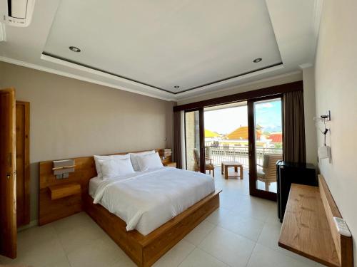 1 dormitorio con cama, TV y balcón en Sandat Living, en Canggu