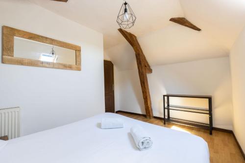a bedroom with a white bed and a mirror at Cacatoès in Saint-Aignan