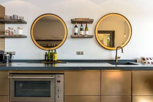 a kitchen with two mirrors and a sink at Lifestyle Villa Cap Martinet Ibiza in Talamanca