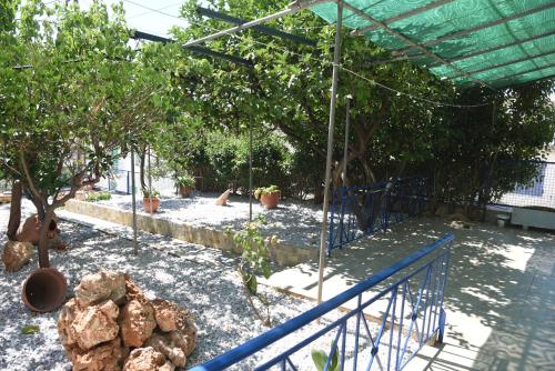 a garden with a pool and trees and a fence at J&B Maisonette House in Marmarion