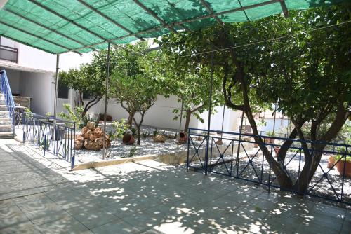 a fence around a garden with trees in it at J&B Maisonette House in Marmarion