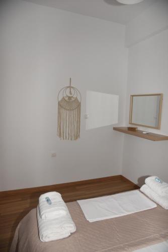 a white room with a bed with towels on it at J&B Maisonette House in Marmarion