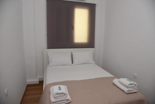 a small bedroom with a bed with towels on it at J&B Maisonette House in Marmarion