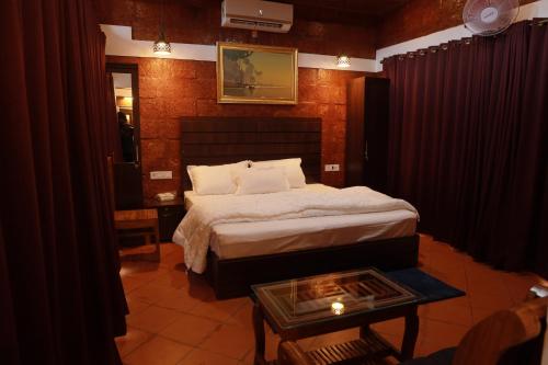a bedroom with a bed and a table in a room at Miracle Holidays in Mananthavady
