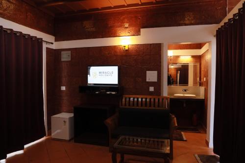a living room with a couch and a television at Miracle Holidays in Mananthavady