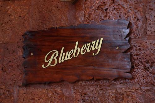 a sign on a brick wall with the word blueberry at Miracle Holidays in Mananthavady