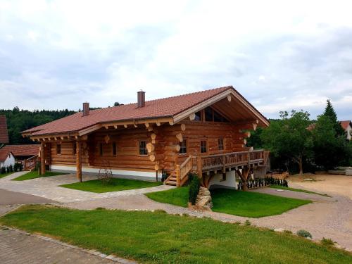 a large log cabin with a large porch and a porch at Hüttenzauber Laumer in Wörth an der Donau