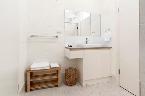 un bagno bianco con lavandino e specchio di Riversands Rest Accommodation Paringa - Tea Tree Cottage a Renmark
