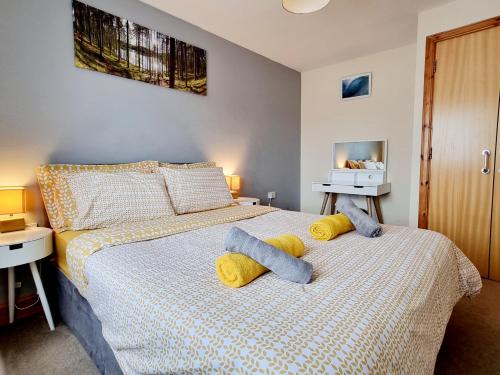 a bedroom with a bed with two towels on it at Modern 2 bedroom garden flat in Inverness