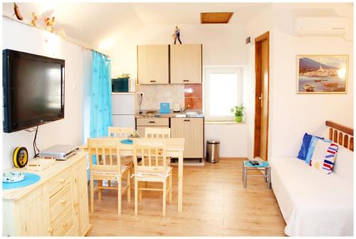 a small living room with a table and a kitchen at Apartment in the centre of Trogir in Trogir
