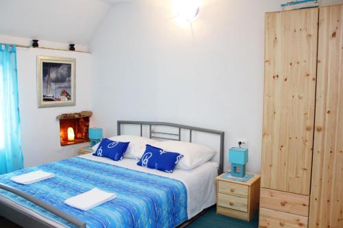 a bedroom with a large bed with blue pillows at Apartment in the centre of Trogir in Trogir