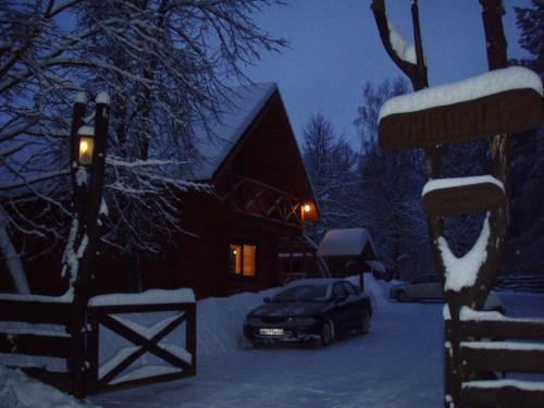 a car parked in front of a house in the snow at Sodyba Duburiai in Ukmergė