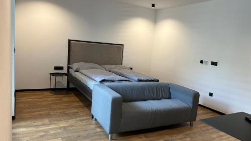 1 dormitorio con 1 cama y 1 silla en Kamel club restaurace a penzion, en Olomouc