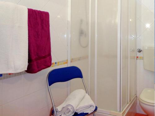 bagno con doccia e sedia blu di Monolocale in Centro Tuttialmare Castellammare del Golfo Sicilia a Castellammare del Golfo