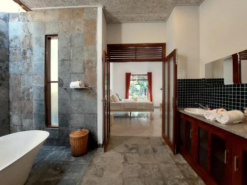 a bathroom with a tub and a sink at Villa Kelapa in Lovina