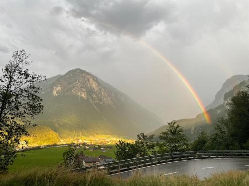 a rainbow over a valley with a mountain at Hotel Hof und Post in Innertkirchen