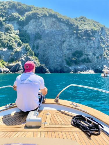 a man sitting on the front of a boat in the water at Agriturismo Costa di Faraggiana in Levanto