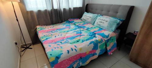 ein Bett mit farbenfroher Bettdecke in einem Schlafzimmer in der Unterkunft Imanz Homestay 3 Bedroom & 3 Bathroom in Kajang
